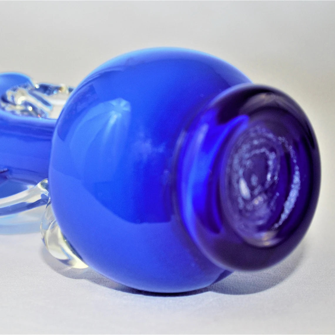 Close-up of a blue and purple glass vase on a white background