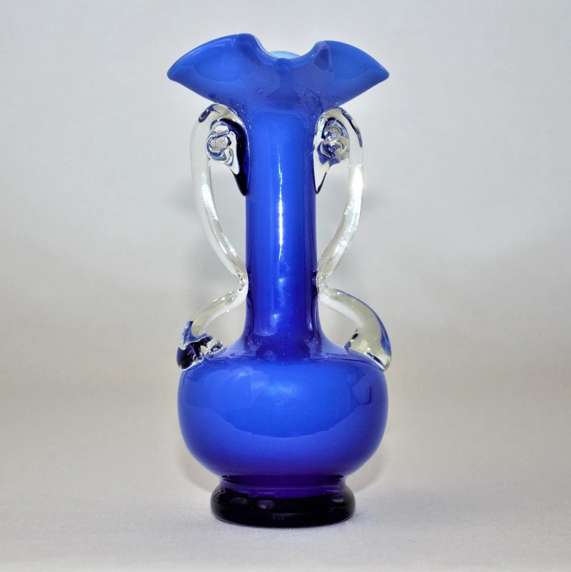 Blue glass vase with clear handles on a white background
