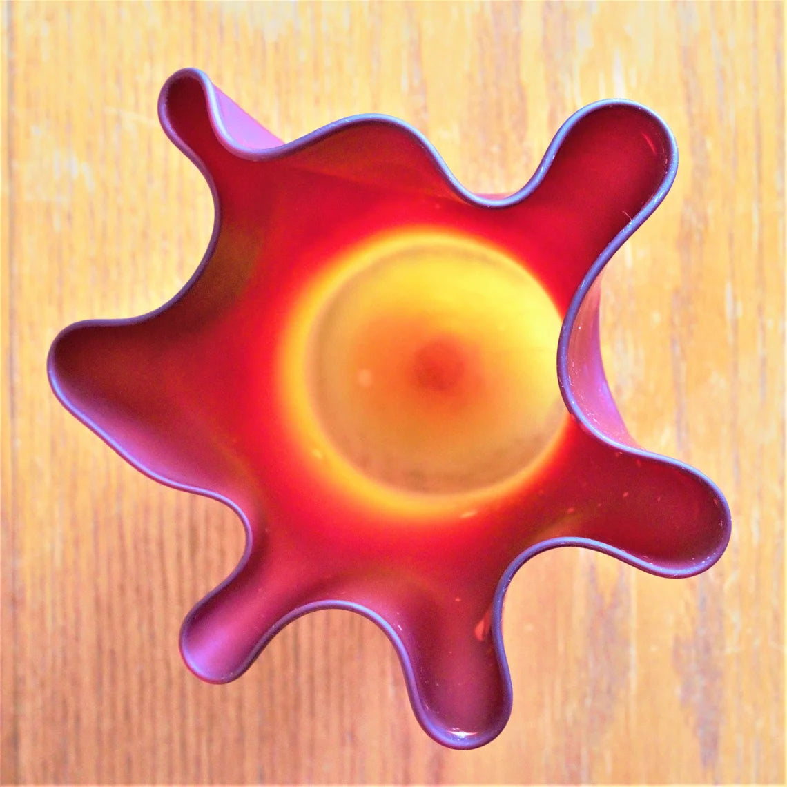 Colorful glass bowl with a star-like design on a wooden surface