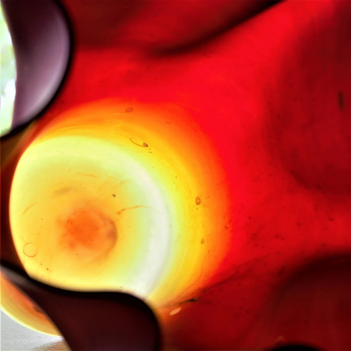 Close-up of a red and yellow glass vase with a blurred background