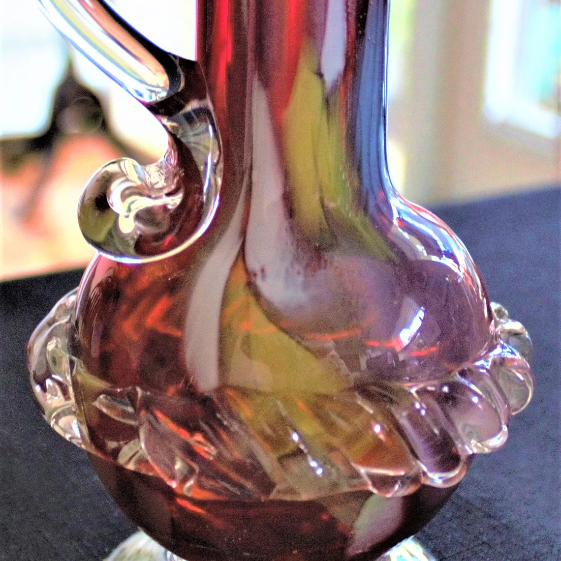 Multicolored glass vase with swirling patterns on a blurred background