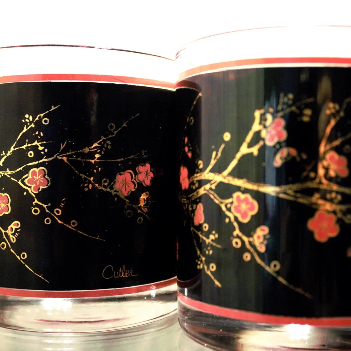 Two glasses with floral design on a black background