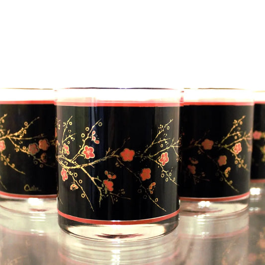 Set of three glass tumblers with black floral design on a white background